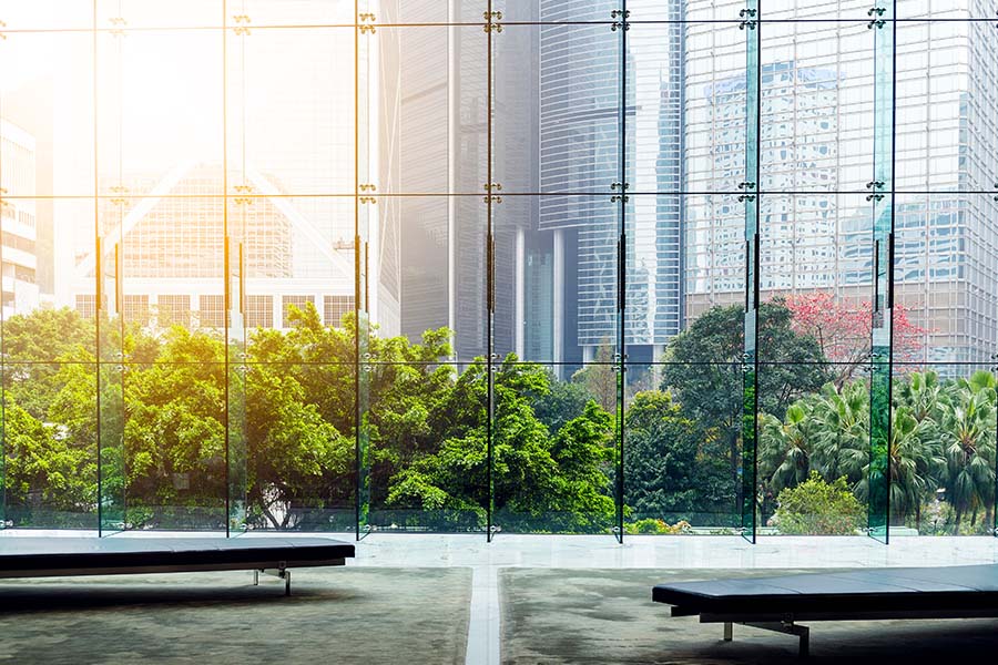 Bryan, OH - Glass Wall in a Modern Office Building Showing Reflection of Buildings and outside Courtyard with Trees