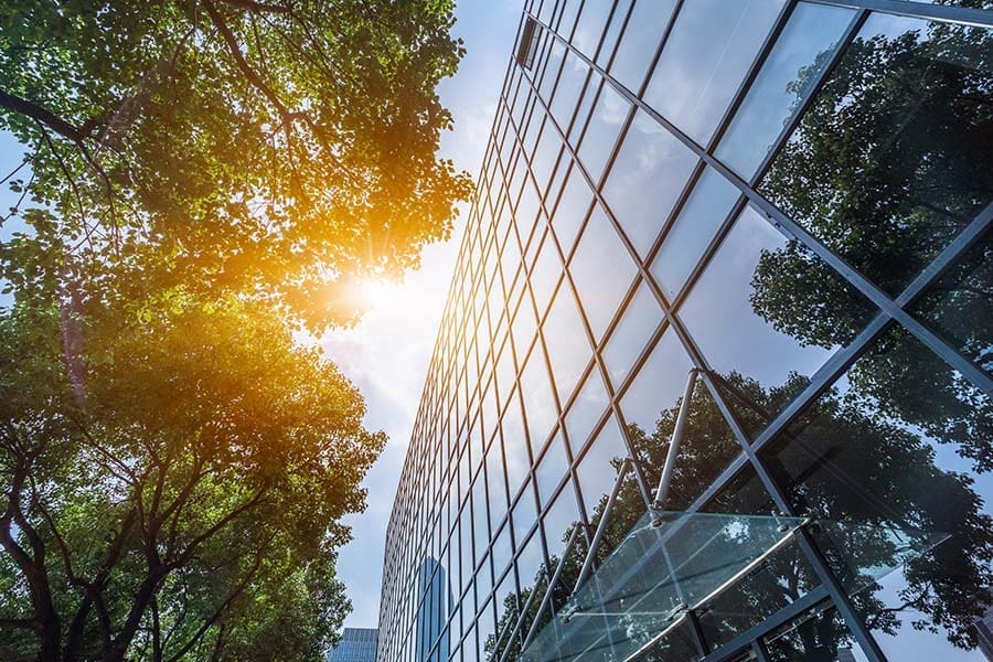 Wauseon, OH - Angled View Looking up at a Modern Office Building with Green Trees on a Sunny Day